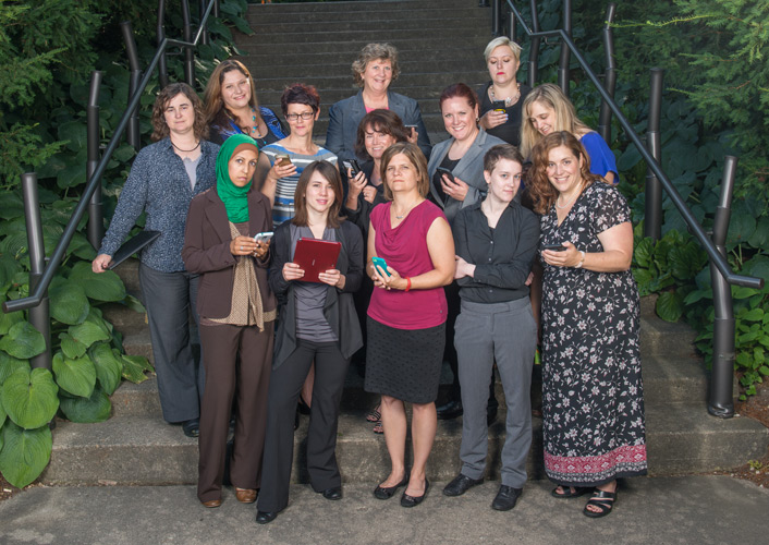 women technology professionals holding phones/tablets
