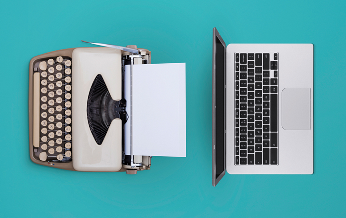 overhead photo of a typwriter on the left and a laptop on the right on a green background