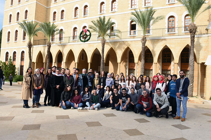 Group of people posing in front of a building.