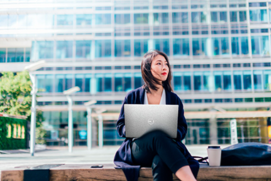 Woman sitting outside using a laptop