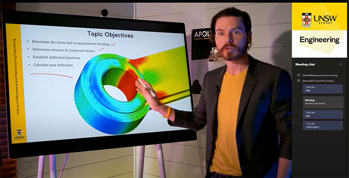 Professor David Kellermann pointing to large screen with 'Topic Objectives' at the top.