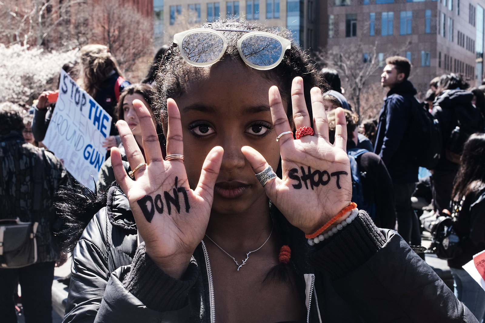 Woman holding up her hands. One hand says Don't. The other hand says Shoot.