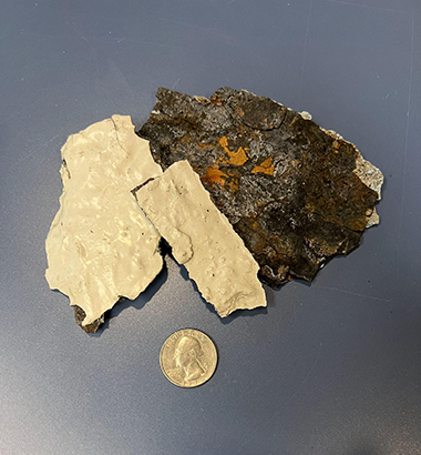 pieces of rusted pipe next to a quarter
