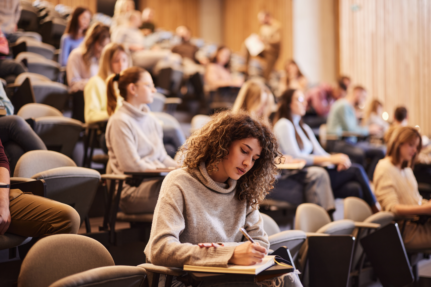Student in a lecture hall taking notes