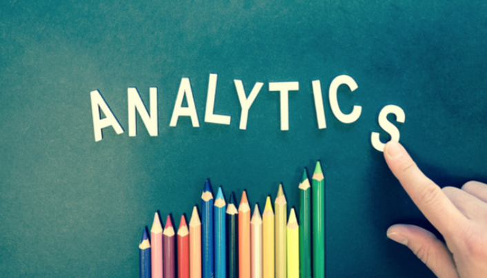 Analytics image - the word Analytics on board above colored pencils