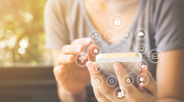 woman holding mobile device overlaid with sphere of technical icons