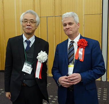 photo of John O'Brien chatting with Professor Masao Kitano (President of AXIES, Vice President at Kyoto University)