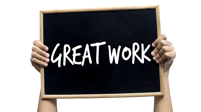 picture of person's arms holding up a small black chalkboard with the words GREAT WORK written on it in white chalk