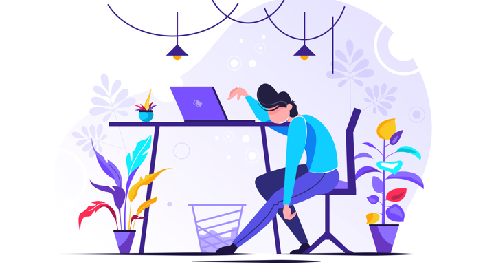 Exhausted person sitting at a table with a laptop.