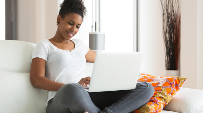 woman sitting on a sofa working on her laptop