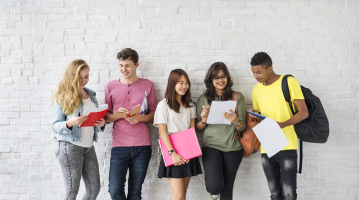 Group of students holding papers and notebooks