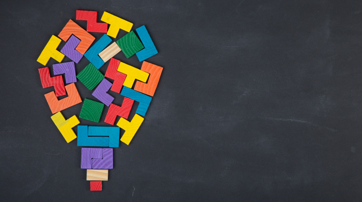 light bulb composed of jigsaw color block on the blackboard