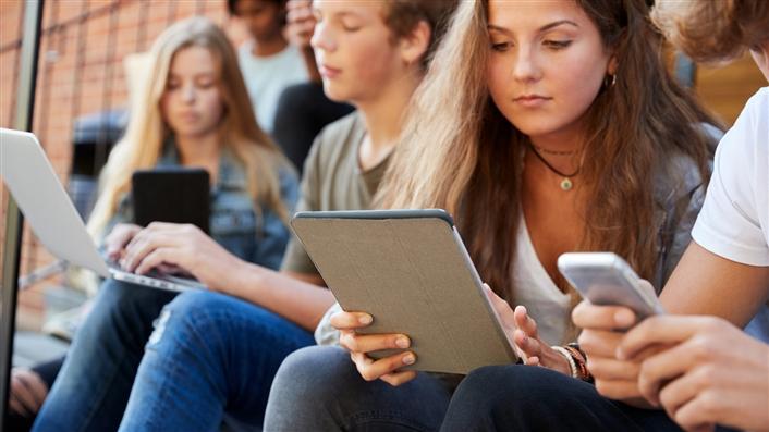 Group of college students working on mobile devices