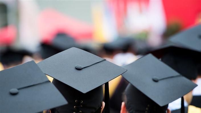 Group of students, shown from behind, wearing their mortarboard caps