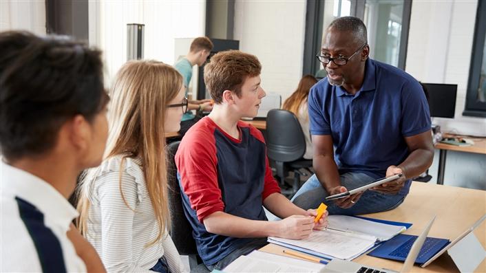 Professor working with three students